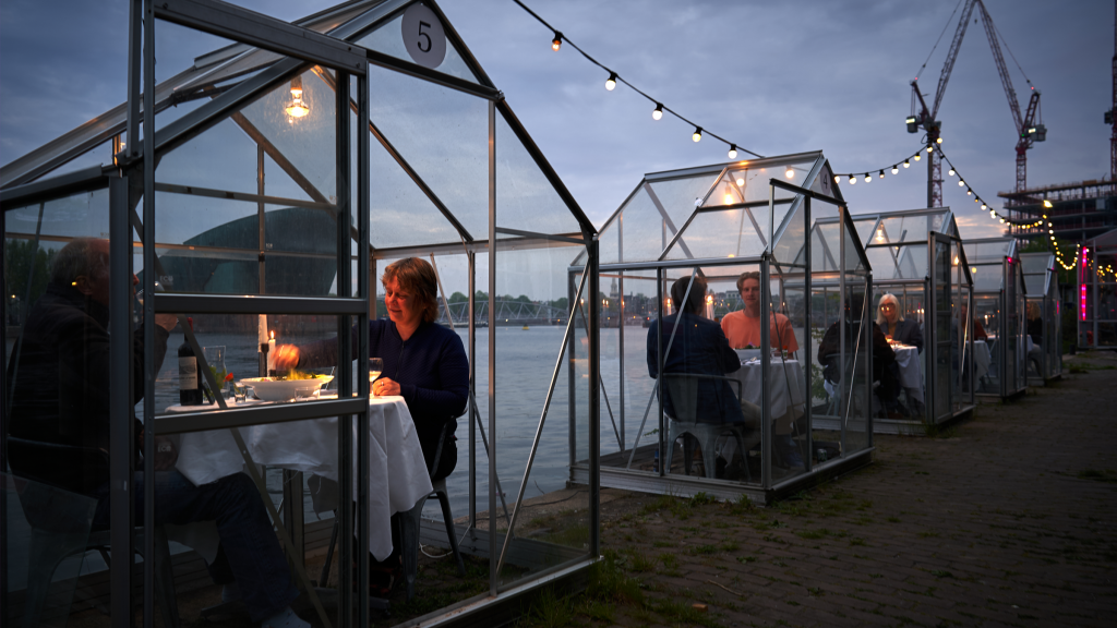 Les clients du restaurant Mediamatic à Amsterdam mangent dans des petites serres