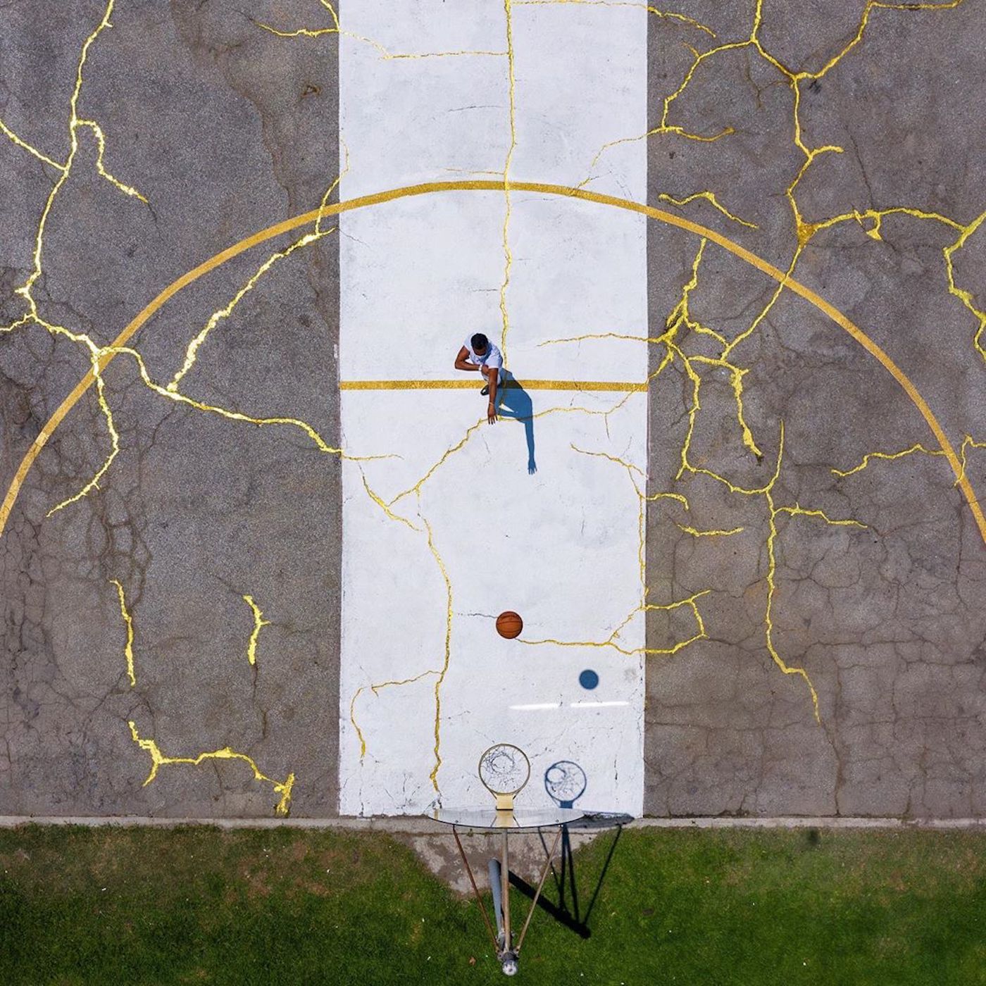 L'artiste Victor Solomon répare un terrain basket avec de la poudre d'or